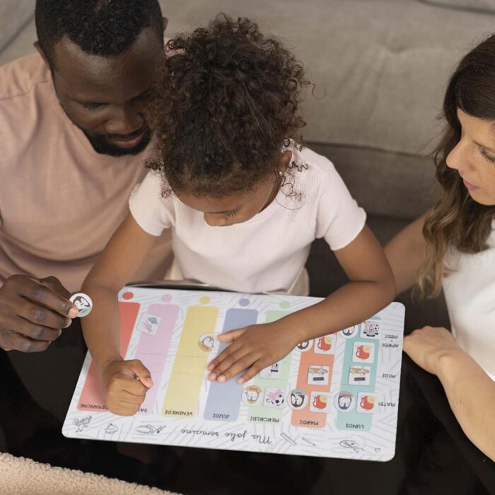 enfant organisant son planning avec des magnets famille sur un semainier