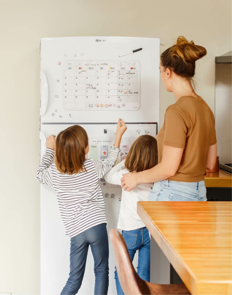 Famille organisant la nouvelle année avec un calendrier magnétique éducatif pour enfants et parents
