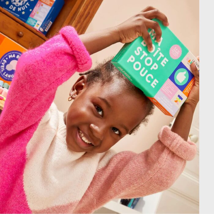 Enfant souriant utilisant la boîte stop pouce pour arrêter de sucer son pouce